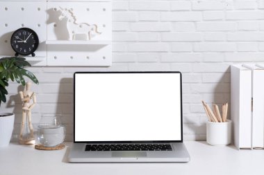 Ön manzara boş ekranlı laptop, beyaz masadaki ofis malzemeleri gibi..