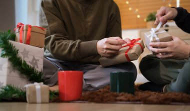 Arkadaşların Noel hediyelerini açarken, süslenmiş bir Noel ağacının yanında otururken..