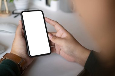 Cropped shot businessman using smart phone while sitting at his workplace.	