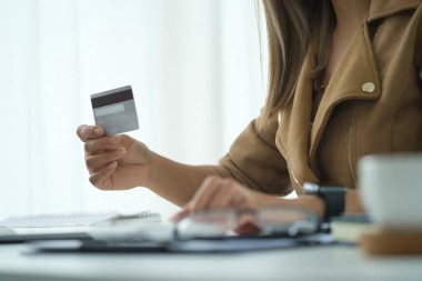 Happy woman holding credit card in her hand. Online shopping, e-commerce concept.	
