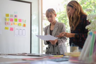 Smiling female graphic designer working with new startup project in modern office.	