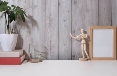 Boş çerçeveli yaratıcı iş yeri, saksı bitkisi, kitaplar ve bir bardak su. Metnin için boşluk kopyala.