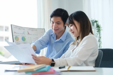 Two young web application developer working on design project for mobile applications at creative office.	