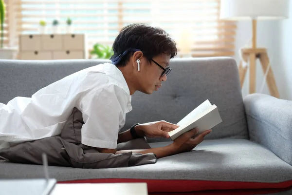 Young Man Lying Comfortable Sofa Reading Book — Stok fotoğraf