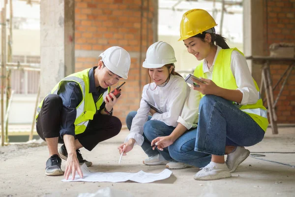 身穿安全制服的男女工程师或建筑师正在建筑工地集思广益 进行工作规划 — 图库照片