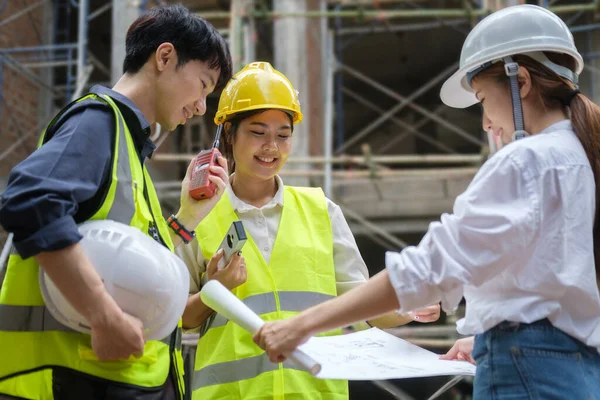 建筑商佩戴安全帽讨论 测量建筑工地布局 — 图库照片