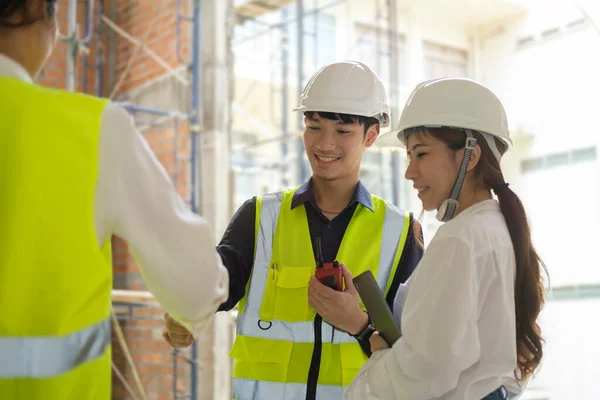身穿黄色背心的工程师在建筑工地工作时握手 建筑合作概念 — 图库照片