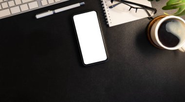 Boş ekranlı akıllı telefonu, kahve bardaklarını ve siyah deri arka plandaki tedarikçileri taklit et..