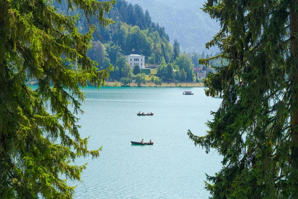 Lake Bled, Slovenia - August 20, 2018: Recreational and tourist boats pass through its turquoise waters amid a green natural landscape