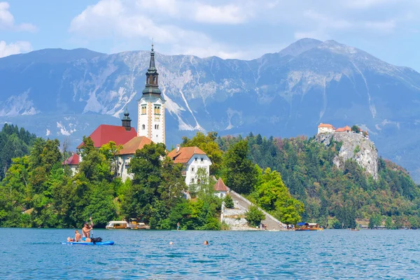 Lake Bled, Slovenia - August 20, 2018: People enjoy the water in summer among a green and lush natural landscape and some magnificent architecture