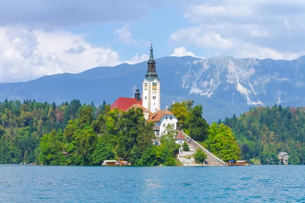 Lake Bled, Slovenia - August 20, 2018: A summer view of Bled Island and its Assumption of Mary Church amid a green and blue landscape