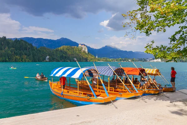 Lake Bled, Slovenia - August 20, 2018: Some traditional 'pletna' boats wait for tourists to take them into the blue-turquoise waters