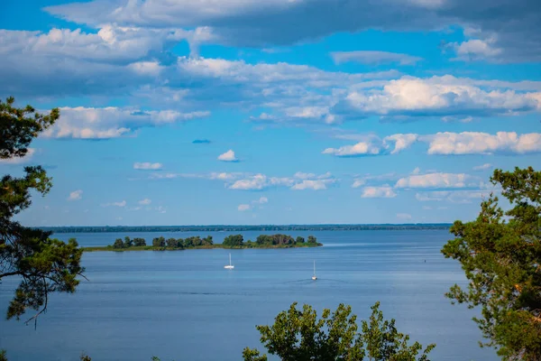 Sıcak bir yaz gününde nehirde renkli bir manzara. Dnipro, Ukrayna. Nehirde iki yat geziyor..