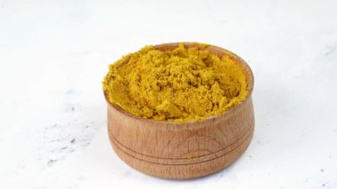 Ahşap kaşık baharatlarıyla ahşap baharat kavanozundan köri ya da zerdeçal alan aşçı..