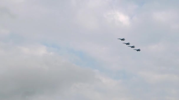 Vier militaire vliegtuigen in formatie vliegen hoog in de lucht boven de stad. Luchtmachtparade. — Stockvideo