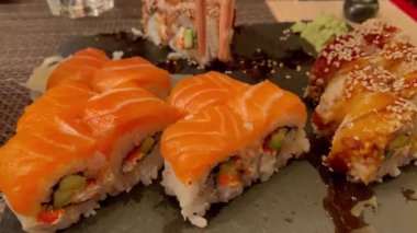 Japon yemeği. Ahşap tahtadan çubuklarla somon balığı rulosu al..