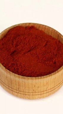 Şef baharatları ahşap baharat kavanozundan kuru kırmızı biber alıyor. Yakın plan..