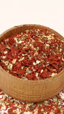 Şef kurutulmuş domates, acı biber ve diğer baharatları ahşap baharat kavanozundan alıyor. Yakın plan..