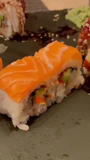 Japansk mat. Ta lax sushi rulle med ätpinnar från träskiva. — Stockvideo