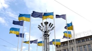 Kiev, Ukrayna, Temmuz 2021 - Kiev 'deki Avrupa meydanı, Avrupa Birliği bayrağı taşıyan bayrak direkleri ve şehir meydanında mavi gökyüzüne karşı dalgalanan Ukrayna. Yakın plan..