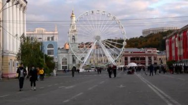 Kiev, Ukrayna Temmuz 2021: - Kyiv 'deki Kontraktova Meydanı' nda mavi gökyüzü arka planında büyük beyaz dönme dolap ve yürüyen insanlar. Yakın plan..
