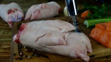 Şef, pişirmek için çiğ domuz budu pişiriyor. Elle pişirilen meşale ateşini kullanarak sebzelerle lezzetli stoklar yapıyor. Gaz ocağı kullanarak yemek yakın..