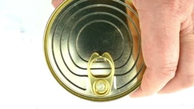 El, beyaz soslu metal teneke konserve somon konservesini açar. Metal kapağı kaldırıyor. Sağlıklı konserve yiyecek konsepti. Üst görünüm.
