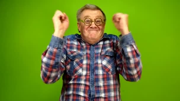 Adulto maturo strano uomo in occhiali stupidi è emotivamente felice di qualcosa, alzare le mani e li scuote con gioia. Schermo verde. — Video Stock