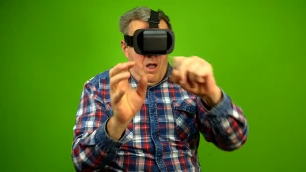 Ώριμος ενήλικας που χρησιμοποιεί γυαλιά εικονικής πραγματικότητας είναι συναισθηματικά παιχνίδι, σηκώστε τα χέρια και τα χέρια σας κύμα. Πράσινη οθόνη. — Αρχείο Βίντεο