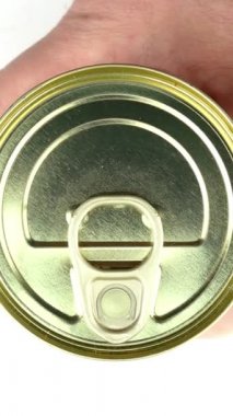 El, marine edilmiş yeşil zeytinle metal teneke kutuyu açar. Metal kapağı kaldırır..