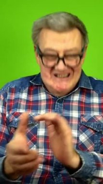 Aptal gözlüklü yetişkin bir adam duygusal olarak ellerini çırpıyor..