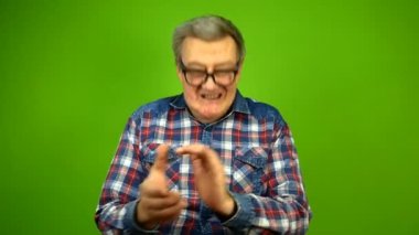 Aptal gözlüklü yetişkin bir adam duygusal olarak ellerini çırpıyor..