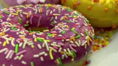 Kremalı ve serpiştirilmiş çeşitli lezzetli çörekler beyaz tabakta dönüyor..