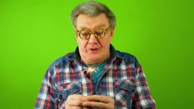 Kafkasyalı yetişkin bir adam maytaplara sert bir şekilde üflüyor ve onu söndürememesine şaşıyor..