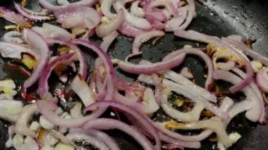 Mutfakta fırında yemek pişirmek için kızartma tavasında doğranmış soğan..