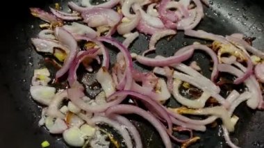 Mutfakta fırında yemek pişirmek için kızartma tavasında doğranmış soğan..