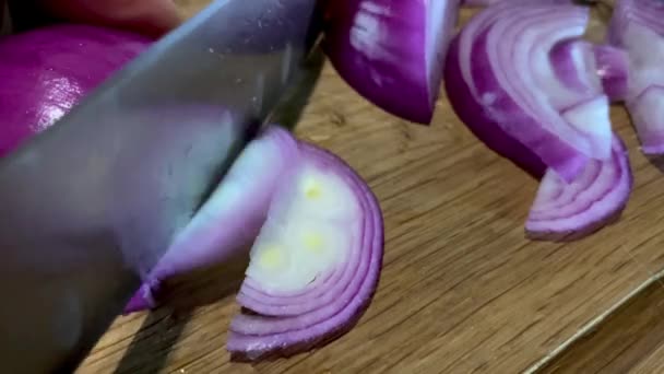Kırmızı soğanı mutfak bıçağıyla doğrama tahtasının üstünde doğramak.. — Stok video