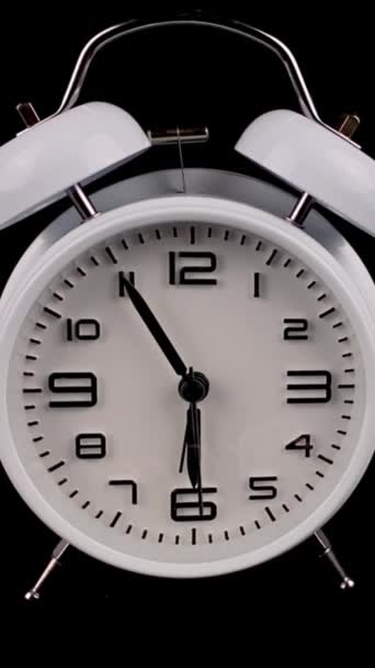 Old fashioned white alarm clock on black background and rings at 6 oclock. — Vídeo de Stock