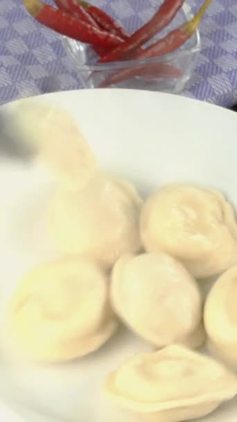 Meat dumplings or ravioli put in white bowl and pour with melted butter. Vertical, Close-up. — Stock Video