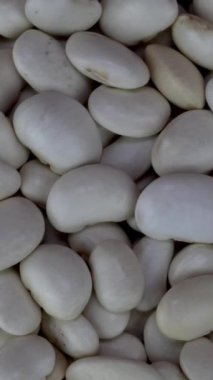 Pikapta yavaşça dönen kuru organik fasulye, yiyecek arka planı. Üst Manzara. Dikey. Yakın plan..