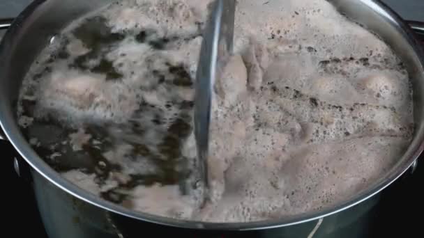 Brodo di carne con abbondante schiuma bolle in casseruola, schiuma viene rimosso con cucchiaio di metallo scanalato. — Video Stock