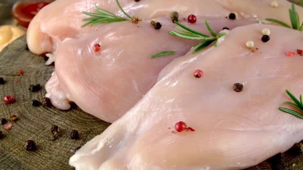 Fresh raw chicken breast fillets sprinkled with peppercorns and rosemary rotates slowly. — Stock Video