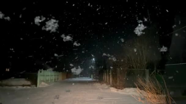 Tergicristallo auto rimuovere fiocchi di neve dal parabrezza del veicolo in piedi sulla nevicata in strada villaggio di notte. — Video Stock