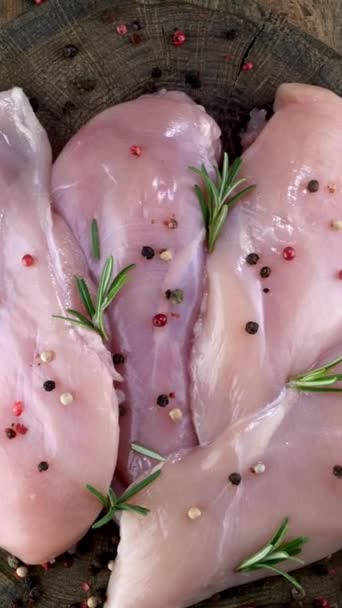 Fresh raw chicken breast fillets sprinkled with peppercorns and rosemary rotates slowly. — Stock Video