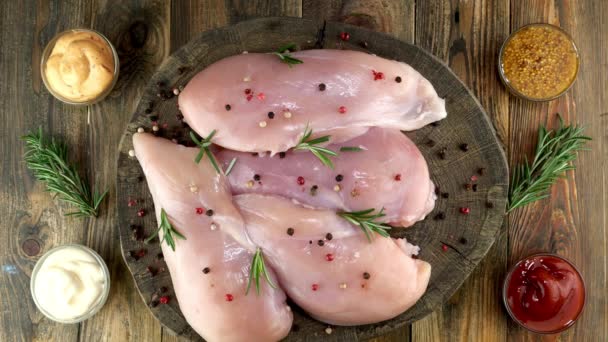 Fresh raw chicken breast fillets sprinkled with peppercorns, rosemary, sauces rotates slowly. — Stock Video