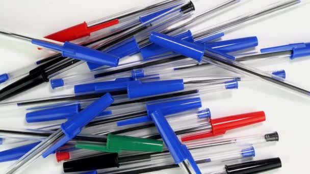 A lot of colorful ballpoint pens spinning rotate slowly on white screen in office or school. — Stock Video