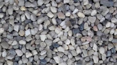 İnşaatta kullanılan gri çakıl taşlarının arka planı yavaşça dönüyor..