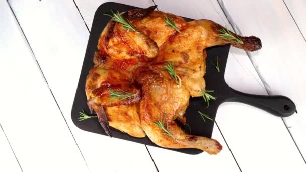 Seluruh ayam panggang dengan rempah-rempah, saus dan kulit renyah di papan potong berputar di atas meja putar. — Stok Video