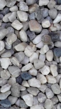 İnşaatta kullanılan gri çakıl taşlarının arka planı yavaşça dönüyor..