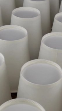 Kahve için tek kullanımlık beyaz bardaklar ya da arka planda sıcak içecekler yavaşça döner..